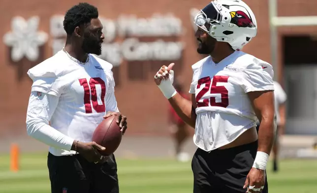 Arizona Cardinals outside linebacker Josh Sweat (10) and linebacker Zaven Collins (25) talk during the NFL football team's practice, Tuesday, June 9, 2026, in Tempe, Ariz. (AP Photo/Rick Scuteri)