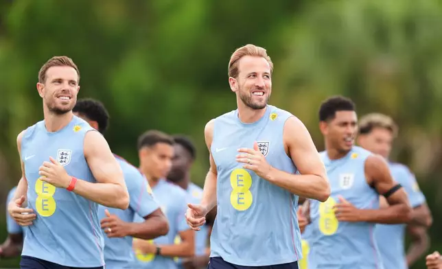 England's Harry Kane, center, and Jordan Henderson, left, jog with teammates during a training for the national soccer team in Palm Beach Gardens, Fla.,Tuesday, June 9, 2026, ahead of the World Cup soccer tournament. (AP Photo/Rebecca Blackwell)
