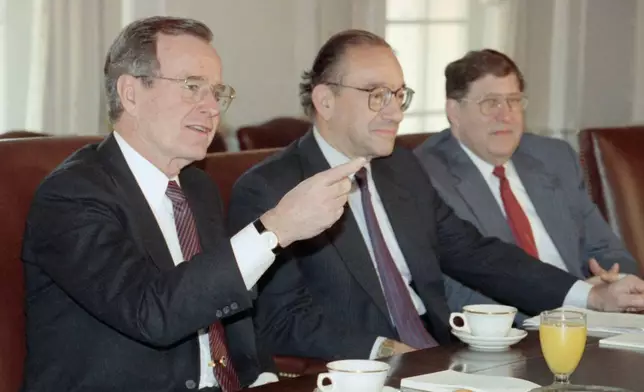 FILE - President George Bush gestures while meeting with economic advisors in the Cabinet Room of the White House, Jan. 15, 1991. Federal Reserve Board Chairman Alan Greenspan, center, and White House Chief of Staff John Sununu look on. (AP Photo/Doug Mills, file)