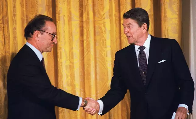 FILE - President Reagan congratulates Alan Greenspan after he was sworn-in as new chairman of the Federal Reserve Board during a ceremony at the White House in this Aug. 11, 1987. (AP Photo/Barry Thumma, file)