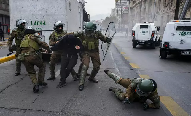Police detain a student during a protest against the government's proposal to lower the education budget, in Santiago, Chile, Wednesday, June 3, 2026. (AP Photo/Esteban Felix)
