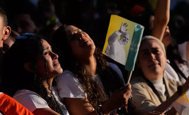 People wait for Pope Leo XIV in Plaza de Lima in Madrid, Saturday, June 6, 2026, for a prayer vigil with young people on the first day of Leo's seven-day apostolic journey to mainland Spain and the Canary Islands. (AP Photo/Alessandra Tarantino)