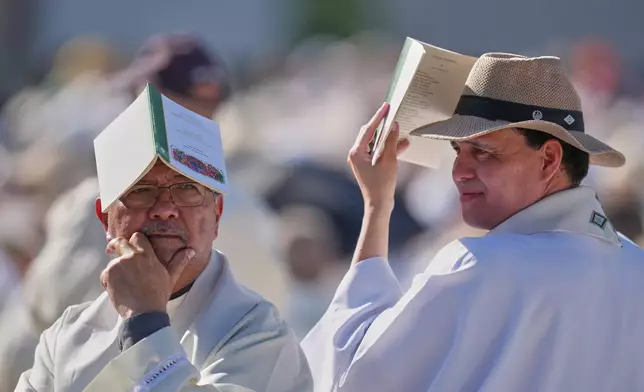 Priests wait for the arrival of Pope Leo XIV ahead of a Holy Mass and Corpus Christi procession at Plaza de Cibeles in Madrid, Spain, Sunday, June 7, 2026, on the second day of his seven-day apostolic visit to mainland Spain and the Canary Islands. (AP Photo/Manu Fernandez)