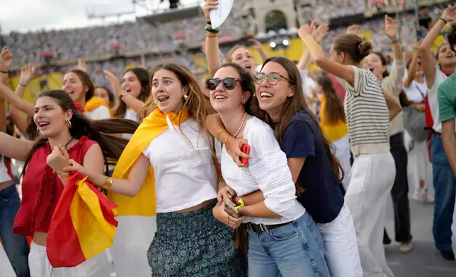 Young people dance to the music before the arrival of Pope Leo XIV to attend a prayer vigil at Lluis Companys Olympic Stadium in Barcelona, Spain, Tuesday, June 9, 2026. (AP Photo/Bernat Armangue)