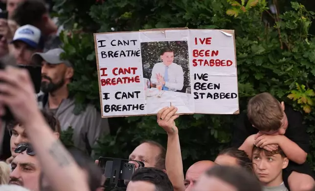People protest outside the police station in Southampton, England, on Tuesday, June 2, 2026, one holding a photo of December 2025 stabbing victim Henry Nowak, 18. (Gareth Fuller/PA via AP)