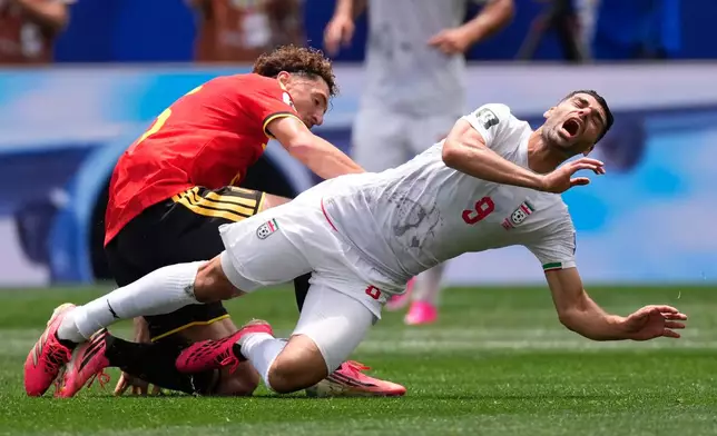 Iran's Mehdi Taremi (9) and Belgium's Thomas Meunier fall during the World Cup Group G soccer match in Inglewood, Calif., near Los Angeles, Sunday, June 21, 2026. (AP Photo/Mark J. Terrill)