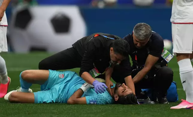 Iran goalkeeper Alireza Beiranvand receives medical assistants during the World Cup Group G soccer match between Belgium and Iran in Inglewood, Calif., near Los Angeles, Sunday, June 21, 2026. (AP Photo/Andre Penner)