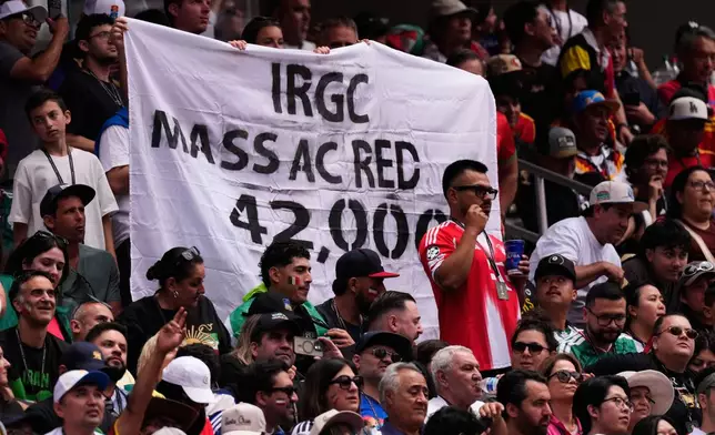 Fans hold up a banner during the World Cup Group G soccer match between Belgium and Iran in Inglewood, Calif., near Los Angeles, Sunday, June 21, 2026. (AP Photo/Mark J. Terrill)