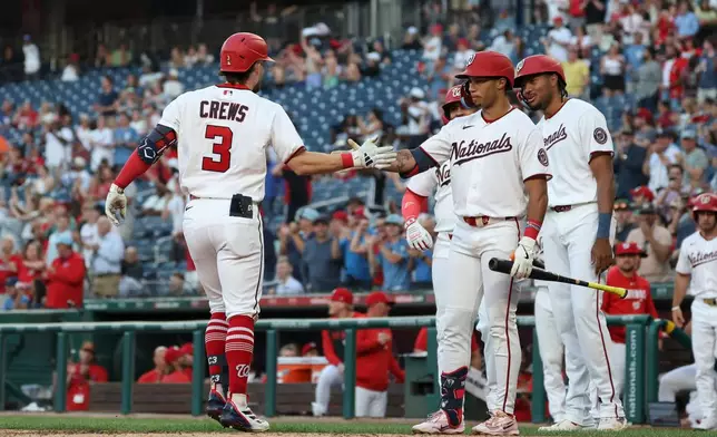 Washington Nationals' Dylan Crews (3) is greeted by Daylen Lile, front right, after hitting a two-run home run off Kansas City Royals pitcher Mason Black which also scored Luis García Jr. during the fifth inning of a baseball game, Monday, June 15, 2026, in Washington. (AP Photo/Terrance Williams)