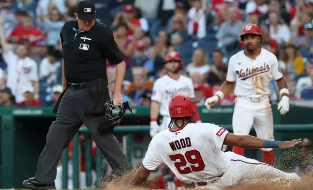 Washington Nationals' James Wood (29) slides into home plate and scores on single hit by Curtis Mead off Kansas City Royals pitcher Mitch Spence during the third inning of a baseball game, Monday, June 15, 2026, in Washington. (AP Photo/Terrance Williams)