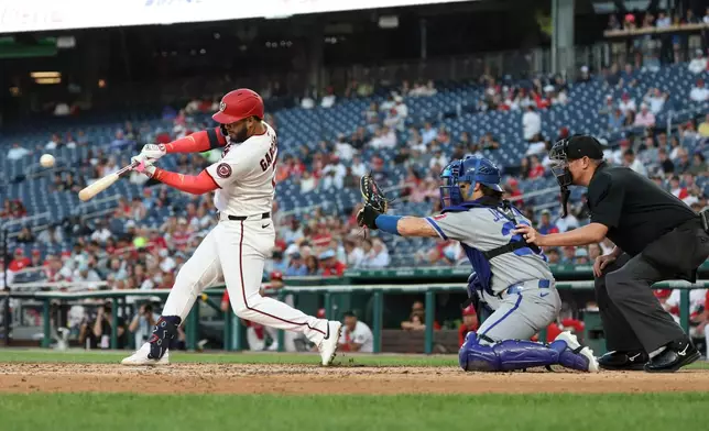 Washington Nationals' Luis García Jr., left, hits a single off Kansas City Royals pitcher Mitch Spence which scored Keibert Ruiz and Nasim Nuñez during the fifth inning of a baseball game, Monday, June 15, 2026, in Washington. (AP Photo/Terrance Williams)
