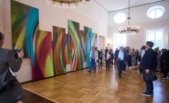 People walk in front of an untitled painting of Katharina Grosse, during the press preview of an exhibition of contemporary art at the German President's residency, Bellevue Palace, in Berlin, Germany, Monday, June 8, 2026. (AP Photo/Markus Schreiber)