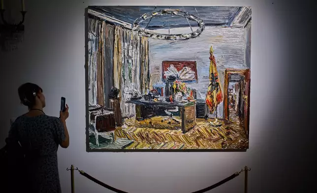 A person takes a photo of the painting "Im Buero des Bundespraesidenten" (In the office of the Federal President), by Christopher Lehmpfuhl, during the press preview of an exhibition of contemporary art at the German President's residency, Bellevue Palace, in Berlin, Germany, Monday, June 8, 2026. (AP Photo/Markus Schreiber)
