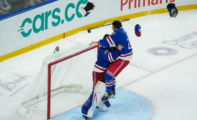 Kitchener Rangers' Jack Pridham, right, leaps into the arms of goalie Christian Kirsch as they celebrate after Kitchener defeated the Everett Silvertips to win the Memorial Cup final hockey game in Kelowna, British Columbia, on Sunday, May 31, 2026. (Darryl Dyck/The Canadian Press via AP)