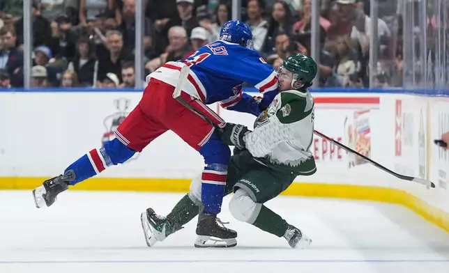 Kitchener Rangers' Jared Woolley (51) checks Everett Silvertips' Carter Bear (11) during the second period of the Memorial Cup final hockey game in Kelowna, British Columbia, Sunday, May 31, 2026. (Darryl Dyck/The Canadian Press via AP)