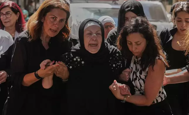 The mother, center, and the wife, left, of the Lebanese Brig. Gen. Wissam Sabra, who was killed Saturday in south Lebanon along with a captain and a soldier in an Israeli airstrike, mourn during his funeral procession in Beirut, Sunday, June 7, 2026. (AP Photo/Hassan Ammar)
