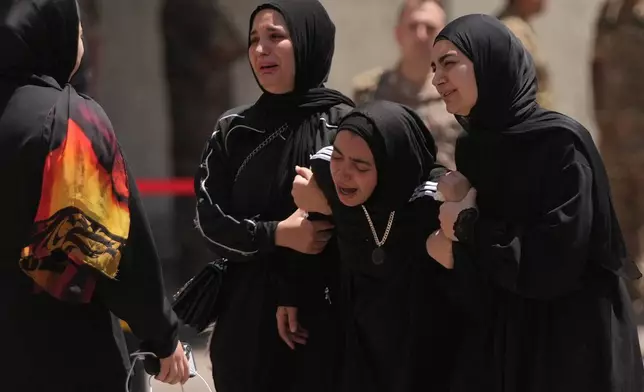 Relatives of the Lebanese soldier Hussein Nazzal, who was killed Saturday in south Lebanon along with a brigadier general and a captain in an Israeli airstrike, mourn during his funeral procession in Beirut, Sunday, June 7, 2026. (AP Photo/Hassan Ammar)