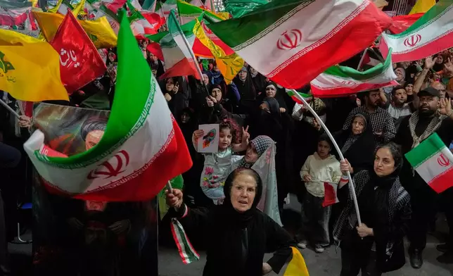 Pro-government Iranian demonstrators wave flags from Iran and Lebanon's Hezbollah in Tehran, Iran, Sunday, June 7, 2026. (AP Photo/Vahid Salemi)