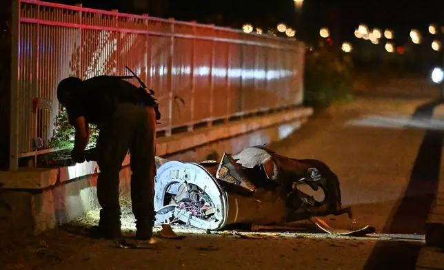 Israeli security forces examine a fragment of an intercepted Iranian missile in northern Israel, early Monday, June 8, 2026. (AP Photo/Rami Shlush)