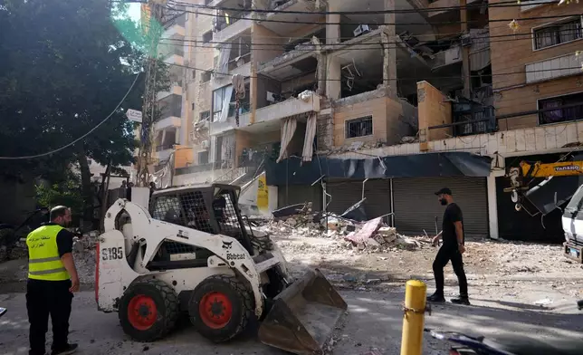 Municipality workers use a skid loader as they remove the rubble of destroyed apartments that where hit by an Israeli airstrike in Dahiyeh, Beirut's southern suburb, Lebanon, Sunday, June 7, 2026. (AP Photo/Hassan Ammar)