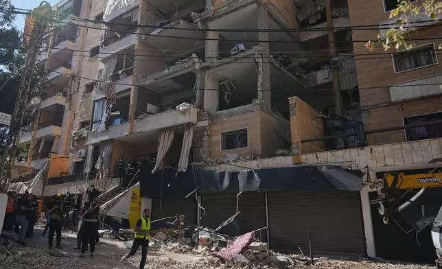 Lebanese security officers gather at the site where an Israeli airstrike hit a building in Dahiyeh, Beirut's southern suburb, Lebanon, Sunday, June 7, 2026. (AP Photo/Hassan Ammar)