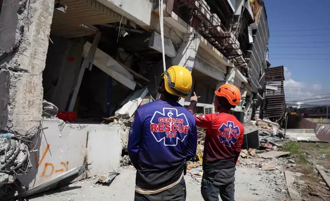 Rescuers inspect a damaged building following an earhtquake in General Santos, Philippines Tuesday, June 9, 2026. (AP Photo/Basilio Sepe)