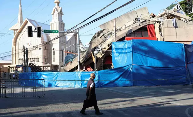 A man walks past a damaged building following an earhtquake in General Santos, Philippines Tuesday, June 9, 2026. (AP Photo/Basilio Sepe)