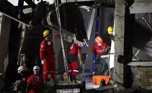Rescuers use heavy equipment as they conduct a search and retrieval operation at a damaged building following an earthquake in General Santos, Philippines, Tuesday, June 9, 2026. (AP Photo/Basilio Sepe)
