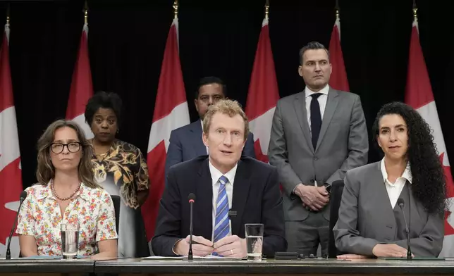 Secretary of State (Children and Youth) Anna Gainey, front left, and MP for Outremont Rachel Bendayan, front right, listen as Canadian Identity and Culture Minister Marc Miller speaks during a news conference in Ottawa, Ontario, Wednesday, June 10, 2026. (Adrian Wyld/The Canadian Press via AP)
