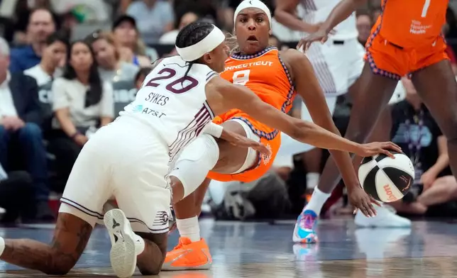 Toronto Tempo's Brittney Sykes (20) and Connecticut Sun's Aaliyah Edwards (8) battle for a loose ball during first half WNBA action in Toronto, Ontario, Wednesday, June 10, 2026. (Frank Gunn/The Canadian Press via AP)