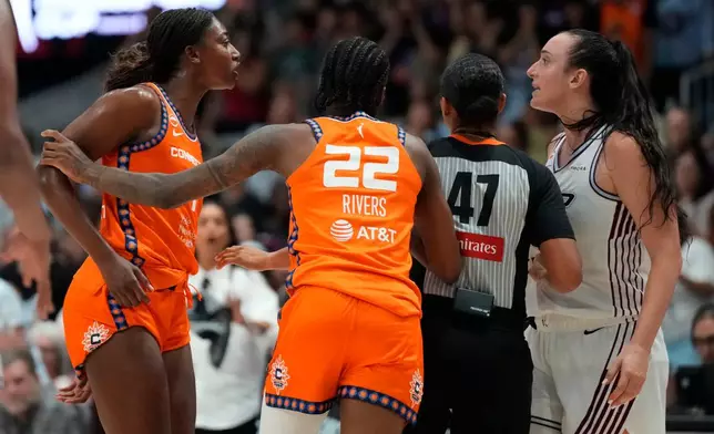 Connecticut Sun's Saniya Rivers (22) and a referee pull apart forward Diamond Miller (1) and Toronto Tempo's Marina Mabrey (3) as they have a scuffle during overtime WNBA action in Toronto, Ontario, Wednesday, June 10, 2026. (Frank Gunn/The Canadian Press via AP)