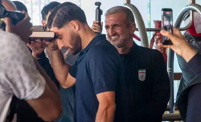 Iran national soccer team member Alireza Jahanbakhsh touches his forehead to the Quran as he departs from the Tijuana Marriott in Tijuana, Mexico on Saturday June 20, 2026. (AP Photo/Gabriela Aoun Angueira)