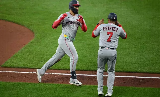 Washington Nationals' Luis Garcia Jr., left, celebrates with third base coach Victor Estevez (7) as he rounds the bases after hitting a home run during the fifth inning of a baseball game against the Baltimore Orioles, Saturday, June 27, 2026, in Baltimore. (AP Photo/Nick Wass)