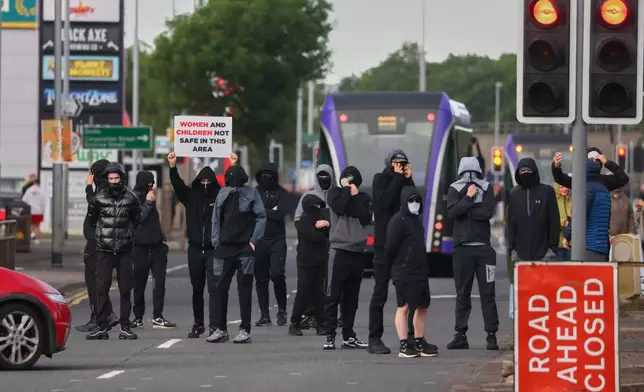 A crowd of protesters gathers in the road following a stabbing incident in North Belfast, Tuesday, June 9, 2026, the stabbing took place late Monday. (AP Photo/Peter Morrison)