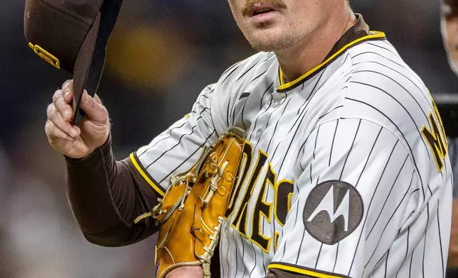 San Diego Padres relief pitcher Ron Marinaccio walks off the field after being pulled in the eighth inning of a baseball game against the Los Angeles Dodgers, Saturday, June 27, 2026, in San Diego. (AP Photo/Tony Ding)