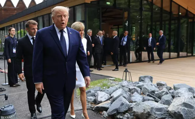 U.S. President Donald Trump walks after posing for a family photo photograph during a gala dinner as part of the G7 summit, in Evian-les-Bains, France, Tuesday June 16, 2026. (Ludovic Marin/Pool Photo via AP)