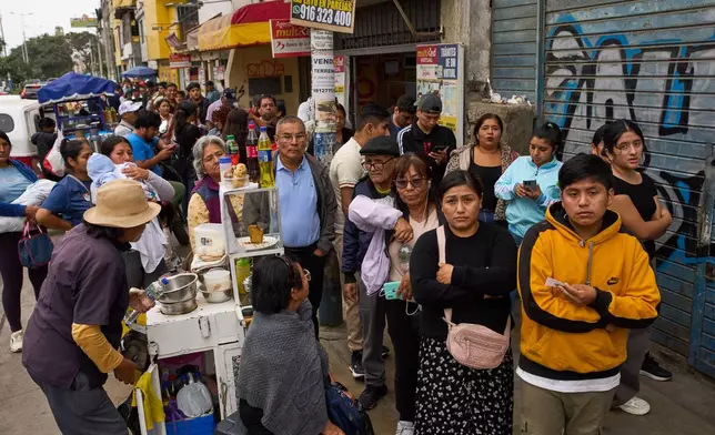People line up to collect their national identity cards ahead of Peru's presidential runoff election in Lima, Peru, Saturday, June 6, 2026. (AP Photo/Rodrigo Abd)