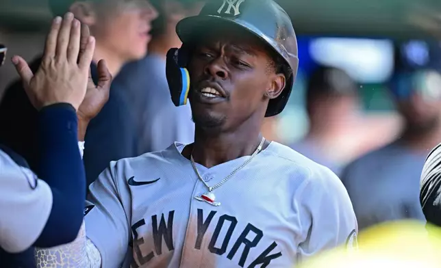 New York Yankees' Jazz Chisholm Jr. is congratulated in the dugout after scoring a run on an error by Cleveland Guardians second basemen Travis Bazzana during the second inning of a baseball game, Wednesday June 10, 2026, in Cleveland. (AP Photo/David Dermer)