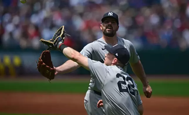 New York Yankees starting pitcher Carlos Rondon, rear, and first baseman Ben Rice reach for a ball hit by Cleveland Guardians' Travis Bazzana during the first inning of a baseball game against, Wednesday, June 10, 2026, in Cleveland. (AP Photo/David Dermer)