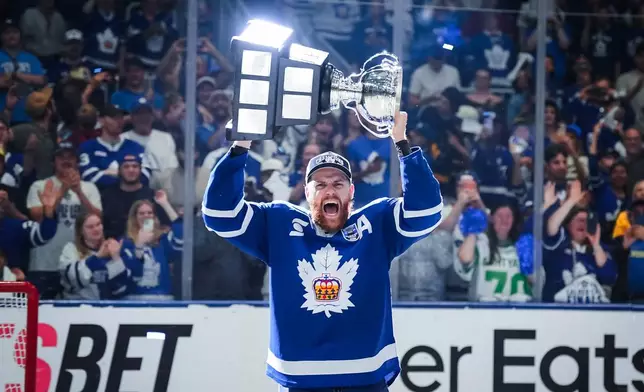 Toronto Marlies defenseman Dakota Mermis (36) hoists the Calder Cup after the Toronto Marlies won Game 5 of the AHL Calder Cup Final over the Chicago Wolves in Toronto on Friday, June 19, 2026. (Arlyn McAdorey/The Canadian Press via AP)