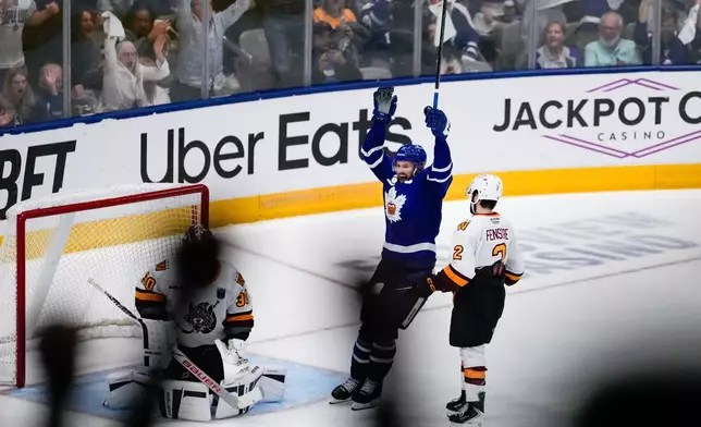 Toronto Marlies' Logan Shaw (11) celebrates after a goal by his teammate Toronto Marlies centre Vinni Lettieri (71) on the Chicago Wolves during the second period in Game 5 of the AHL hockey Calder Cup final in Toronto, Friday, June 19, 2026. (Arlyn McAdorey/The Canadian Press via AP)