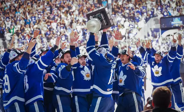Toronto Marlies forward Logan Shaw (11) lifts the Calder Cup to celebrate with his teammates after winning Game 5 of the AHL Calder Cup Final over the Chicago Wolves in Toronto on Friday, June 19, 2026. (Arlyn McAdorey/The Canadian Press via AP)