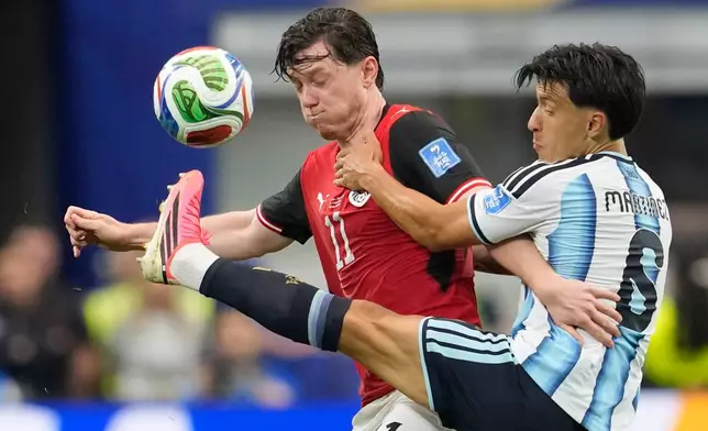 Austria's Michael Gregoritsch (11) and Argentina's Valentin Barco battle for the ball during the World Cup Group J soccer match in Arlington, Texas, near Dallas, Monday, June 22, 2026. (AP Photo/Tony Gutierrez)