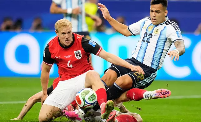 Austria's Xaver Schlager (4), Stefan Posch (not seen) and Argentina's Lautaro Martinez fall during the World Cup Group J soccer match in Arlington, Texas, near Dallas, Monday, June 22, 2026. (AP Photo/Tony Gutierrez)