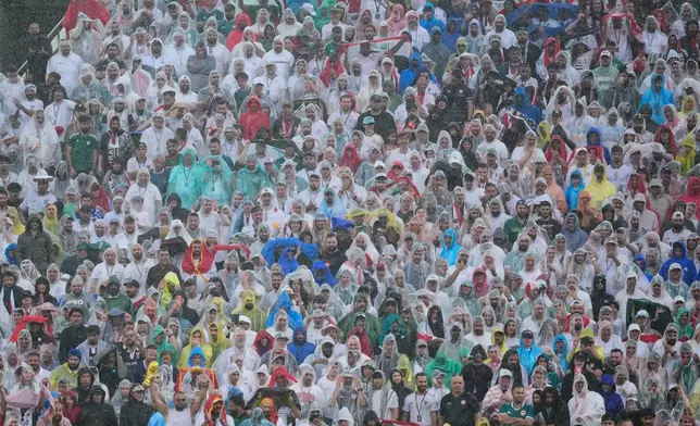 Spectators react in the rain during the World Cup Group I soccer match between France and Iraq in Philadelphia, Monday, June 22, 2026. (AP Photo/Petr David Josek)