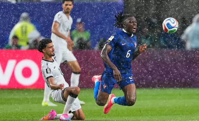 France's Manu Kone (6) reacts as he is tackled by Iraq's Zidane Iqbal (14) during the World Cup Group I soccer match between France and Iraq in Philadelphia, Monday, June 22, 2026. (AP Photo/Petr David Josek)