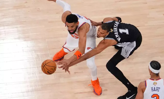 New York Knicks center Karl-Anthony Towns (32) and San Antonio Spurs forward Victor Wembanyama (1) battles for the ball during Game 3 of the NBA Finals basketball series, Monday, June 8, 2026, in New York. (AP Photo/Yuki Iwamura)