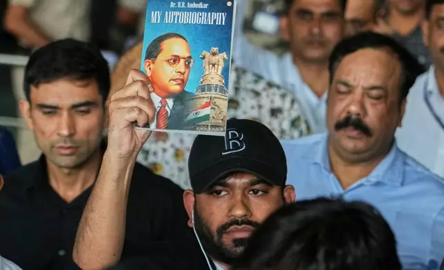 Abhijeet Dipke, center, founder of Cockroach Janta Party shows the autobiography of Bhim Rao Ambedkar as he comes out at Indira Gandhi International airport in New Delhi, India, Saturday, June 6, 2026. (AP Photo/Manish Swarup)