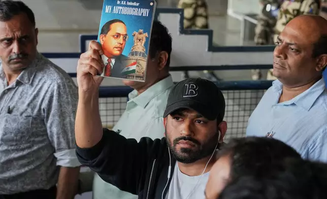 Abhijeet Dipke founder of Cockroach Janta Party shows the autobiography of Bhim Rao Ambedkar as he comes out at Indira Gandhi International airport in New Delhi, India, Saturday, June 6, 2026. (AP Photo/Manish Swarup)