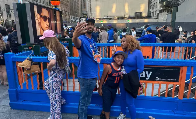 New York Knicks fans pose at a subway entrance in New York decorated in team colors as the Knicks play the San Antonio Spurs in Game 1 of the NBA Finals basketball series on Wednesday, June 3, 2026. (AP Photo/Ted Shaffrey)